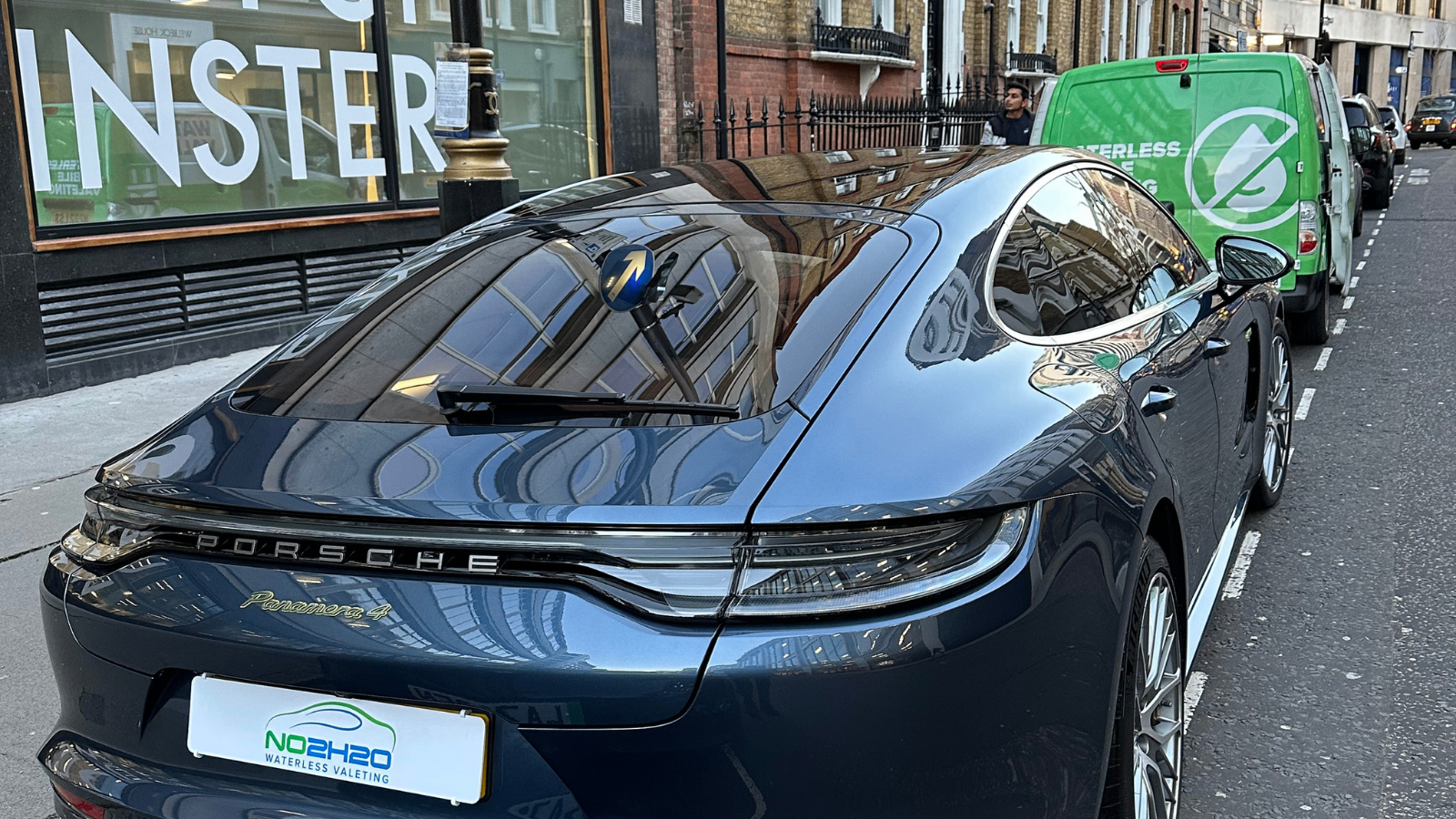 Dark blue Porsche Panamera 4 valeted by NO2H2O next to the branded electric van on a central London street